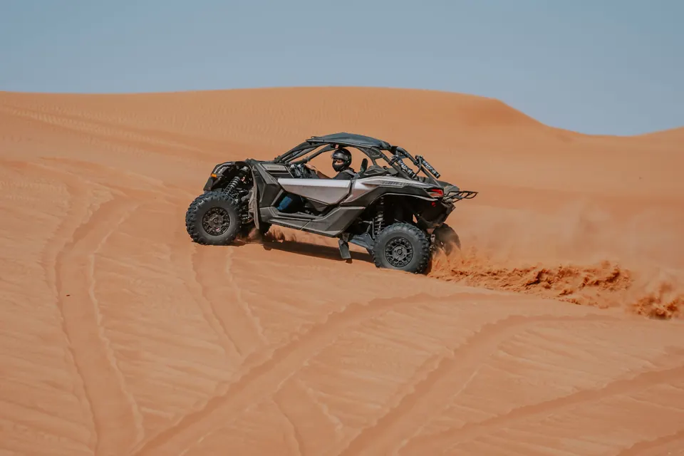 Dune buggy climbing an orange Sahara dune